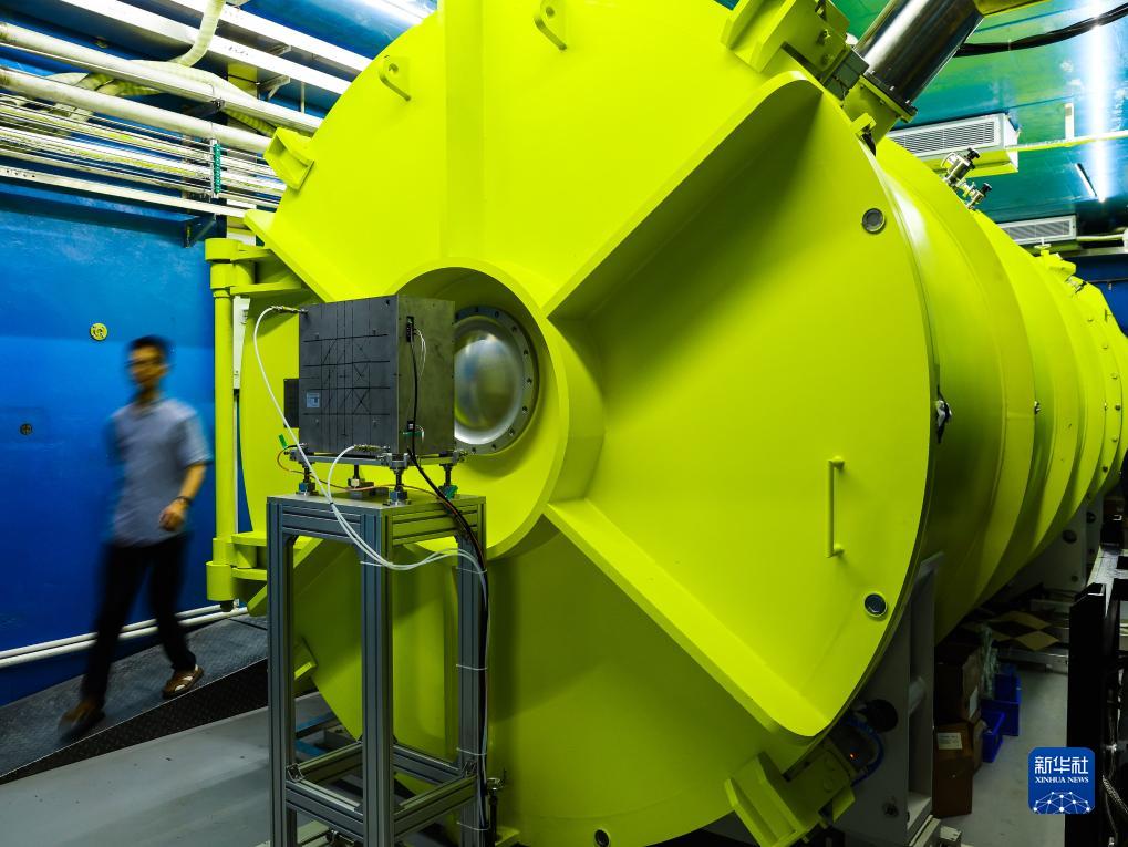 　　科研人员从中国散裂中子源的微小角中子散射谱仪散射腔系统旁经过（7月18日摄）。